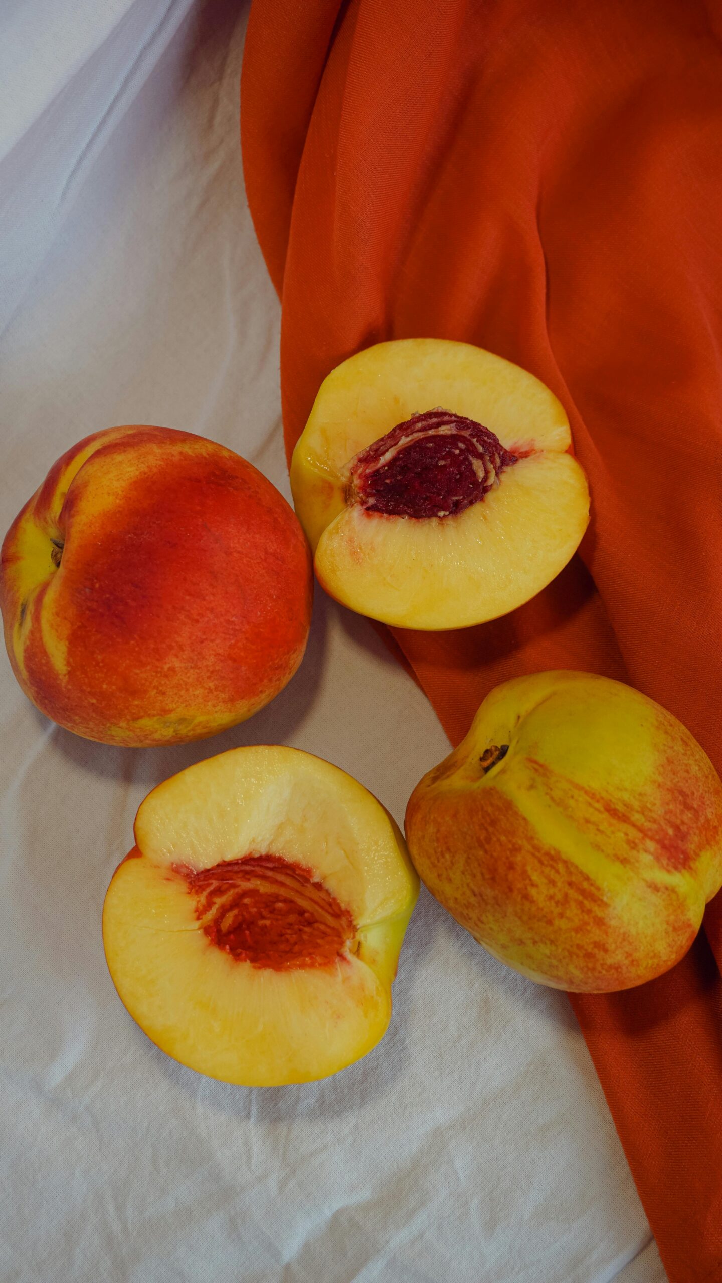 Vibrant, freshly cut peaches on a colorful cloth. Perfect for healthy eating themes.