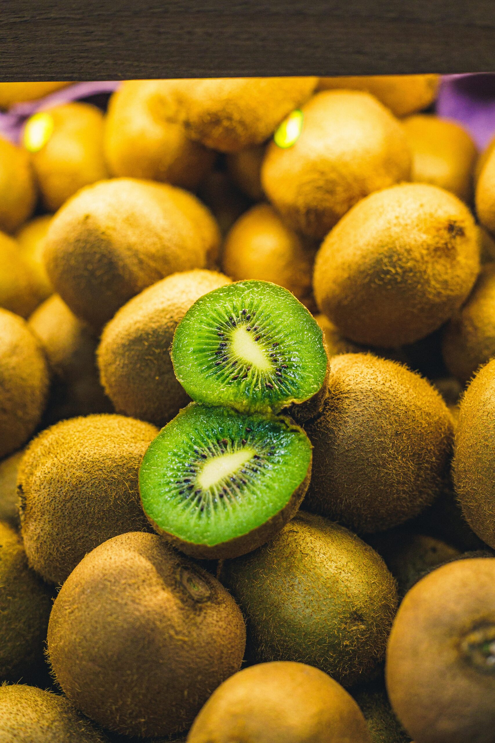 Vibrant fresh kiwi fruits with a sliced center showcasing bright green texture.